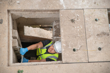 Environmental scientists climb ladders down to drainage channels around the city.