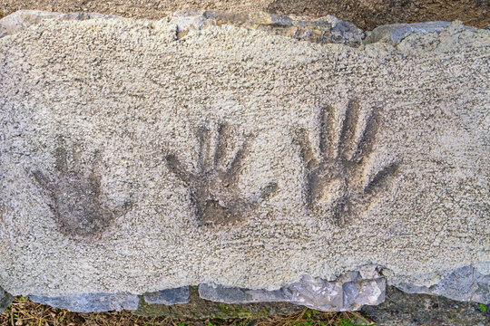 Children's handprints on old concrete pavement