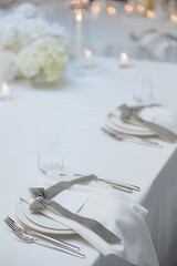 Elegant dining setup with soft white flowers and candlelight ambiance at a special event