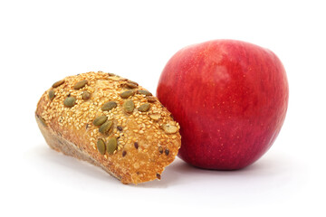Red apple and multigrain bread on white background.