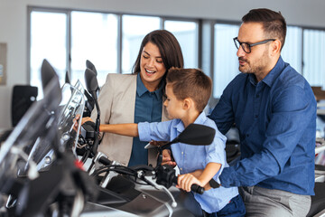 Family Helps Son Ride Motorcycle In Showroom, Learning Together With Joyful Support Before Buying A New Bike