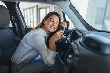 Happy Woman Embracing Steering Wheel Inside Modern Car With a Smile