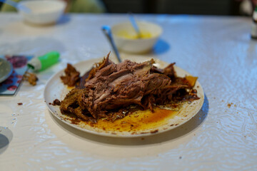 Tender roast meat served on a plate after a family gathering around a dining table in evening light