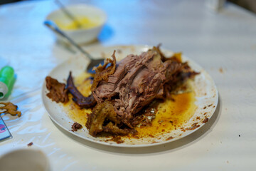 Delicious roast meat served on a plate with sauce remnants at a gathering