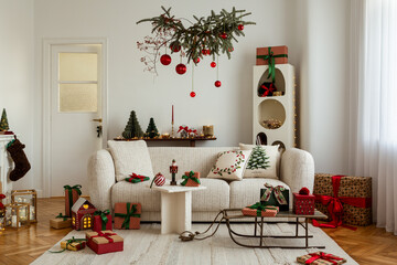 Christmas decorations and wrapped gifts surrounding a textured sofa, with festive lights and a hanging branch above.