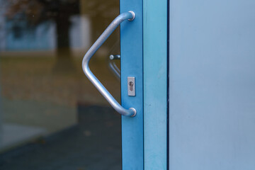 Non-traditional blue door handle and lock captured on a chilly afternoon in an urban neighborhood