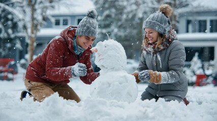 Young couple enjoys winter afternoon crafting a snowman with care while snowflakes fall gently around them in a snowy neighborhood scene - Powered by Adobe