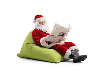 Santa Claus sitting on a bean bag and and reading a newspaper