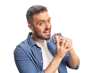 Young man biting a milk chocolate bar