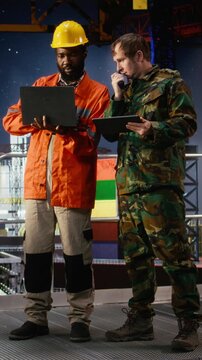 Vertical Video Professional military operative communicates via radio on offshore platform, coordinating with intelligence service units to prevent terrorist threats and ensure mission safety. Camera