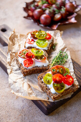 Bruschetta with cream cheese, cherry tomatoes on toasted bread vertical photo