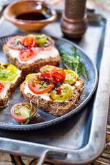 Bruschetta with cream cheese, cherry tomatoes on toasted bread vertical photo close up