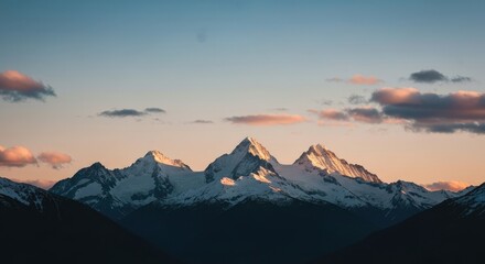 Fototapeta premium Majestic Snow-Capped Mountains with Golden Glow at Sunrise in a Serene Landscape