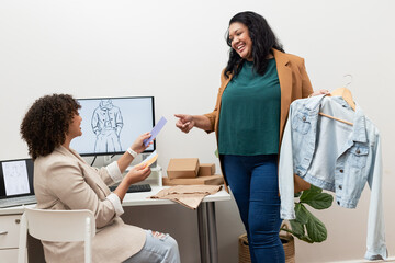 Diverse female colleagues collaborating on design in studio with color swatches and denim jacket