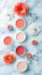 A collection of makeup products, including blush and rose-shaped items, are arranged with flowers on a marble surface.