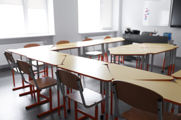 Classroom with yellow desks and chairs at school