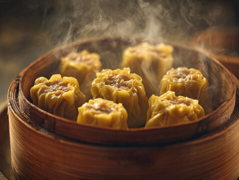 Close-up of handmade siomay dimsum arranged neatly in a bamboo steamer, steam rising softly, rich golden tones, 