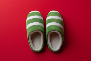 Christmas elf slippers on red background.