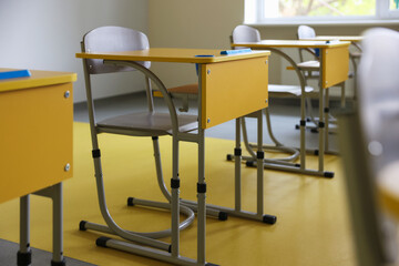 Stylish classroom with desks and chairs at school, closeup