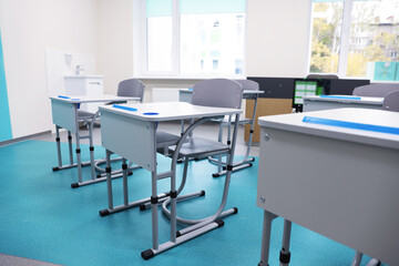 Desk with chairs in classroom at school