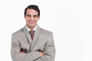 Man smiling and posing with arms crossed in studio portrait wearing suit jacket necktie dress shirt