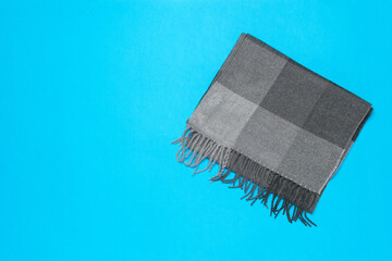 Gray Scarf on a Blue Background: Minimalist Fashion Accessory Photography
