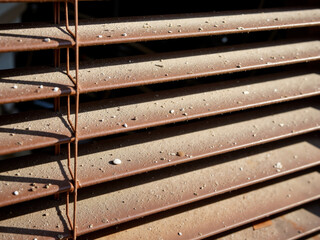 Rustic metal blinds with dirt and dust under sunlight  