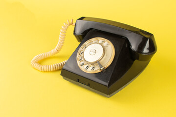 Vintage Black Rotary Phone on Vibrant Yellow Background Retro Communication Concept