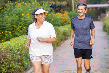 Indian Senior Couple Power Walking Together on a Park Path for Morning Fitness