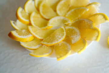 Fresh lemon slices arranged on a plate with a sprinkle of sugar for a sweet and tangy treat