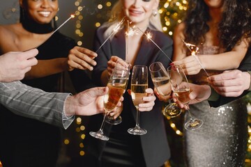 Midsection people holding a glasses with champagne while celebrating New Year