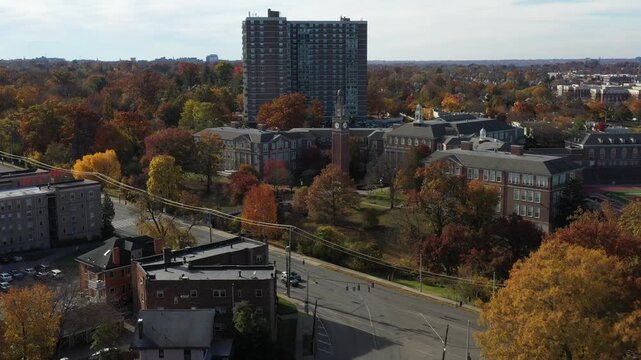 Aerial view of red brick buildings with clock tower and tall building, contrasting with the fall foliage, Cincinnati, Ohio, United States.