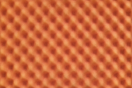 Orange colored egg crate foam sheet packing material dimples background texture.