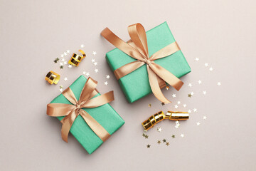Beautiful Christmas gifts, confetti and streamers on beige background, flat lay