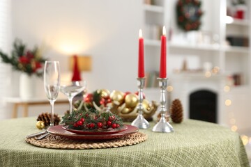 Festive table setting with Christmas decor and burning candles indoors, closeup