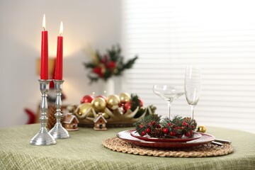 Festive table setting with Christmas decor and burning candles indoors, closeup