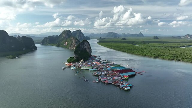 Aerial view of the colorful village of Ko Panyi on the water surrounded by limestone cliffs and green forests, Ko Panyi, Phang Nga, Thailand.
