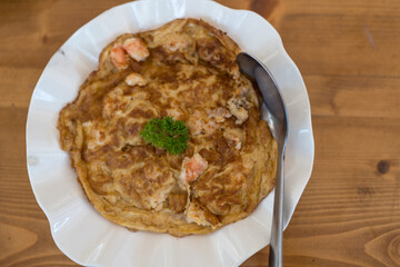 Delicious Thai omelette with shrimp served on white dish. Thai call khao kai jeaw  kung