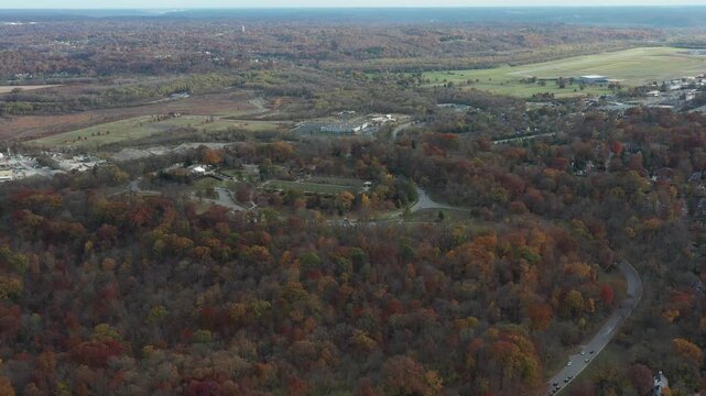 Aerial view of Ault Park showcasing vibrant autumn foliage with a distant view of the Ohio River and Lunken Airport, Cincinnati, Ohio, United States.