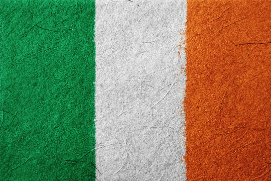 Close-up of a tricolor flag with green, white, and orange vertical bands showcasing a textured, rough surface, evokes a feeling of national pride and cultural identity, ideal for