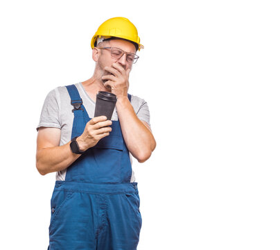 Tired repairman, isolated on white background. Sleepy male with closed eyes holding coffee cup. Middle-aged construction worker covers face. Sleepy expression. Craftsman against white wall
