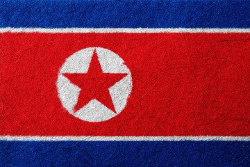 A vibrant textured image displays broad red and blue horizontal stripes, punctuated by a prominent white circle enclosing a red star, rendered in a style reminiscent of graphic art,