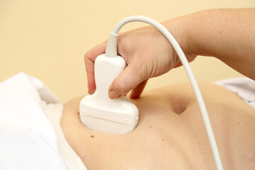 Modern ultrasound device. Ultrasound examination of internal organs. A woman undergoing an ultrasound scan of her abdominal cavity. Ultrasound examination device.   