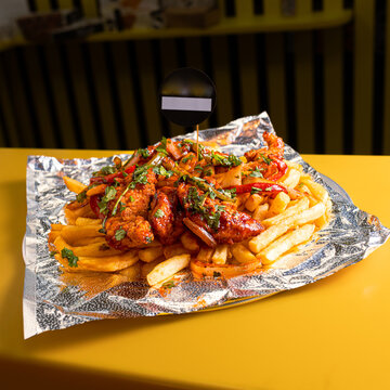 Delicious loaded french fries topped with savory chili and fresh green onions served on a foil lined tray