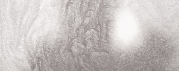 Shimmering silver abstract background. Liquid glitter paint texture waves and swirls. Beautiful shiny white glitter texture. Metallic silver paint close-up as a holiday background.
