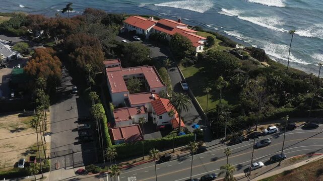 Aerial view of Yogananda Ashram by the ocean, with contrasting red-tiled roofs and lush green trees and the blue ocean, Encinitas, California, United States.