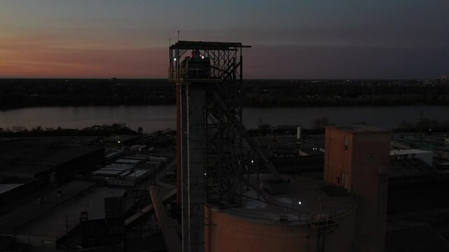 Aerial view of an industrial complex featuring tall chimneys contrasting against the river under a dusky sky, Toledo, Ohio, United States.