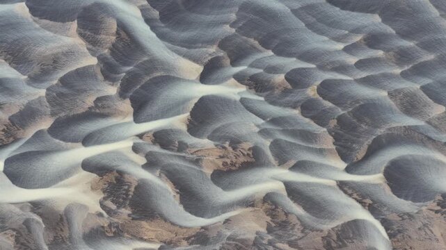 Aerial view of an abstract braided river system creates a mesmerizing pattern of light and dark tones, showcasing nature's artistry, Iceland.