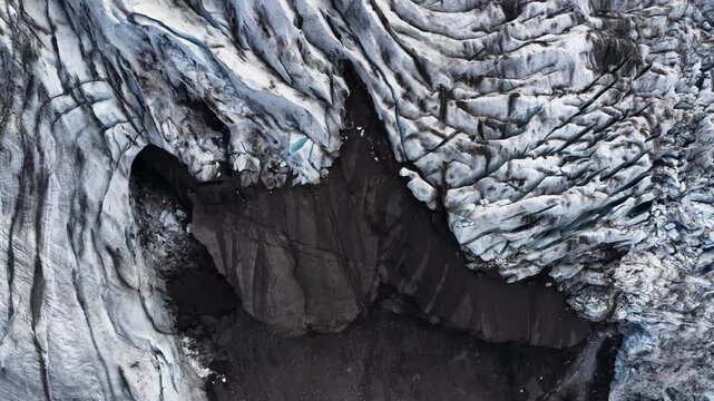 Aerial view of the rugged glacier with contrasting dark and light areas, creating a dramatic landscape texture, Sveitarfelagid Hornafjordur, Iceland.