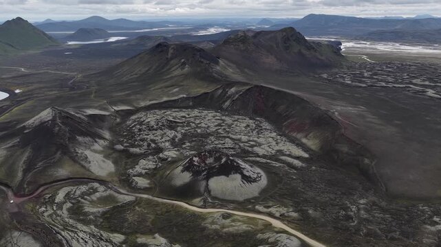 Aerial view of a volcanic landscape featuring dark mountains, mossy fields, and winding rivers, a tableau of textures in Landmannalaugar, Rangarthing ytra, Iceland.